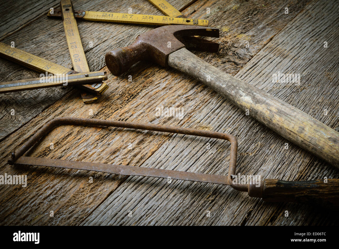 Hammer, Saw and Measuring Tape on Rustic Wood Background Stock Photo