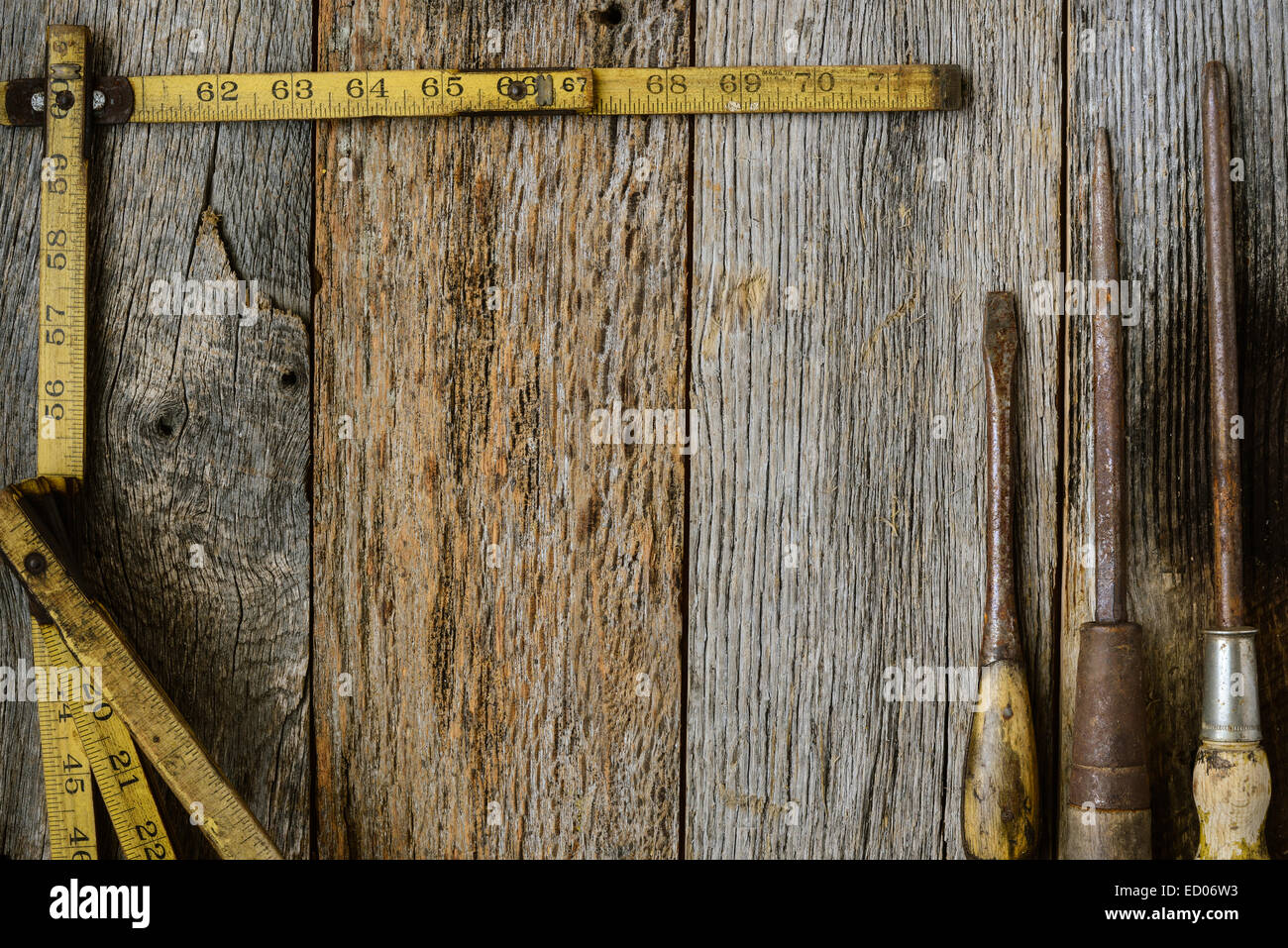 Measuring Tape and Screwdriver on Rustic Old Wood Background Stock Photo