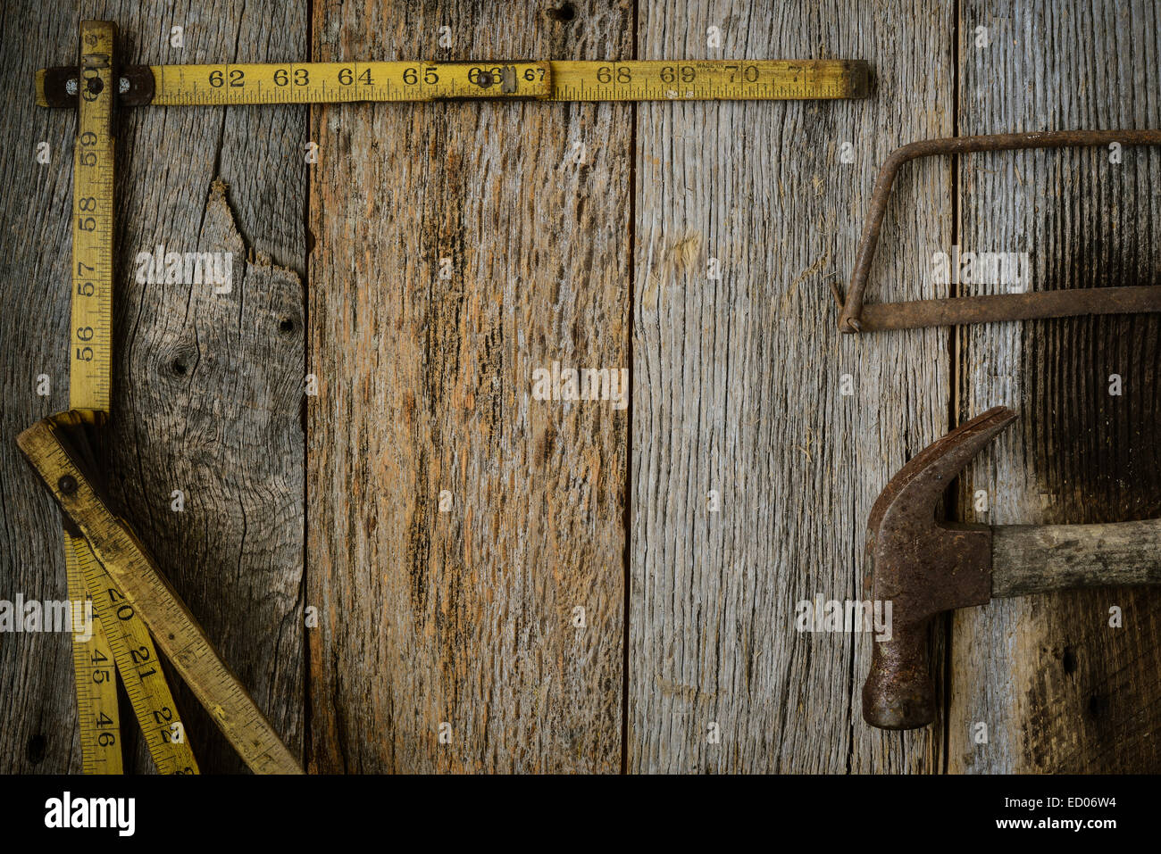 Measuring Tape Hammer and Saw on Rustic Old Wood Background Stock Photo