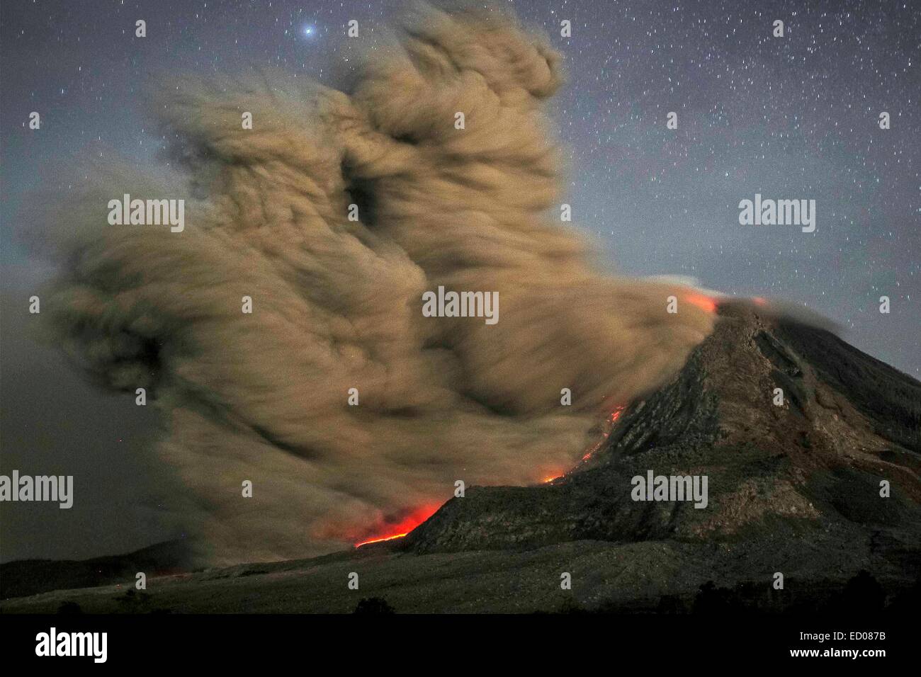 Beijing, China. 14th Oct, 2014. This long exposure photo taken before dawn on Oct. 14, 2014 shows sparks of lightning, scorching lava flow and giant ash clouds released from the crater during the eruption of Mount Sinabung volcano as seen from Karo district located in Sumatra island, Indonesia. In February, Sinabung's eruption killed about 17 people and forced more than 33,000 others to flee their homes. © Tanto H./Xinhua/Alamy Live News Stock Photo