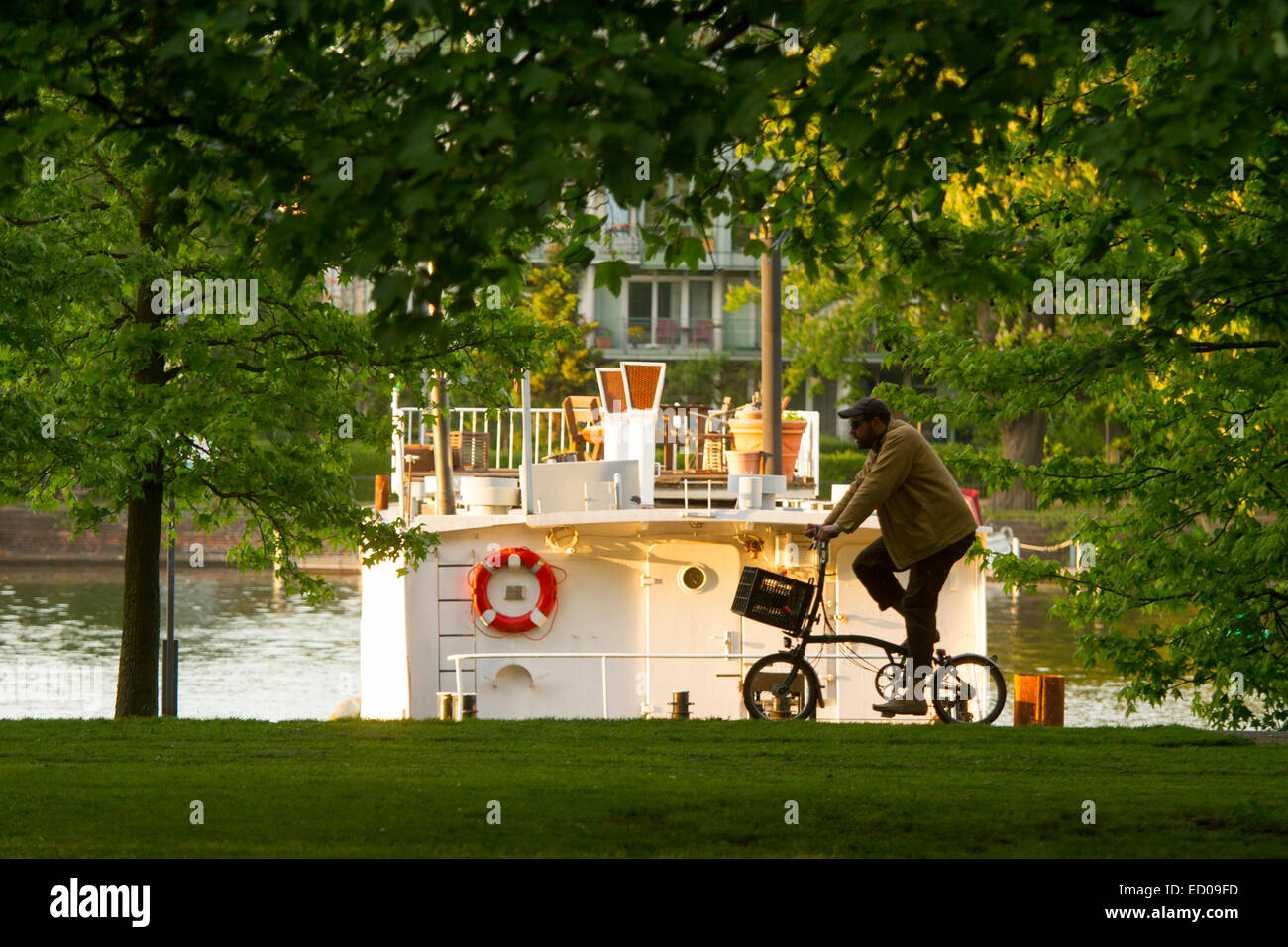 Man riding a bike near Spree river in Treptower Park, Berlin, Germany. Stock Photo