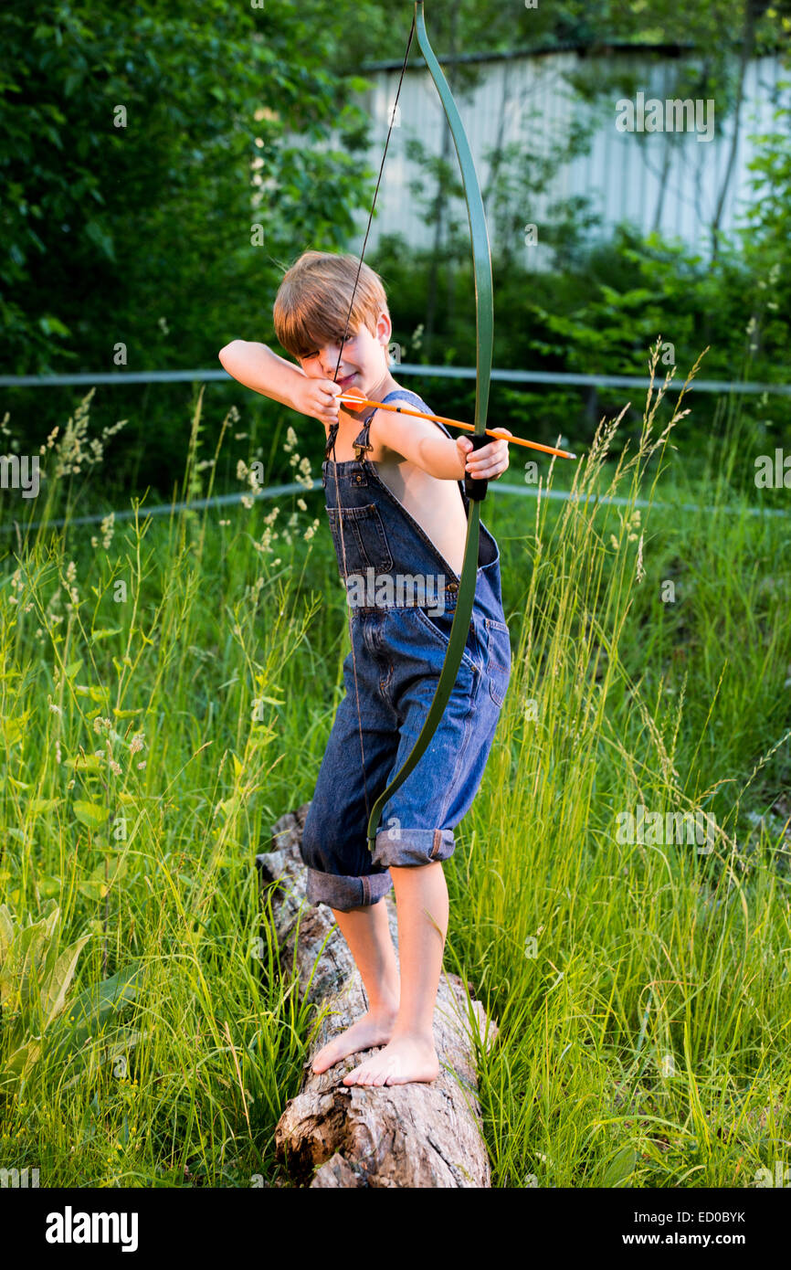 Boy shooting a bow and arrow Stock Photo