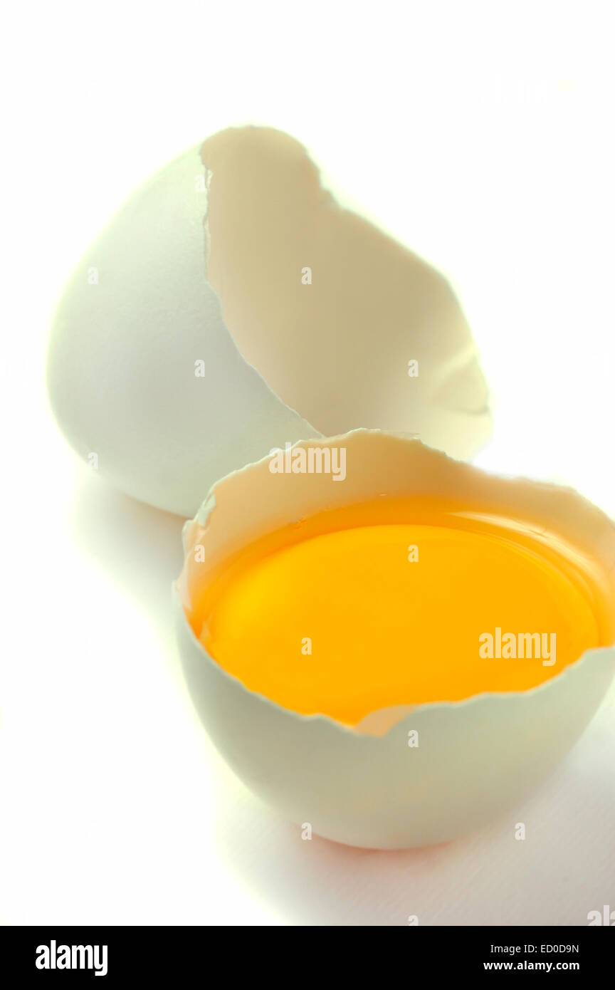 broken white egg, yolk exposed Stock Photo Alamy