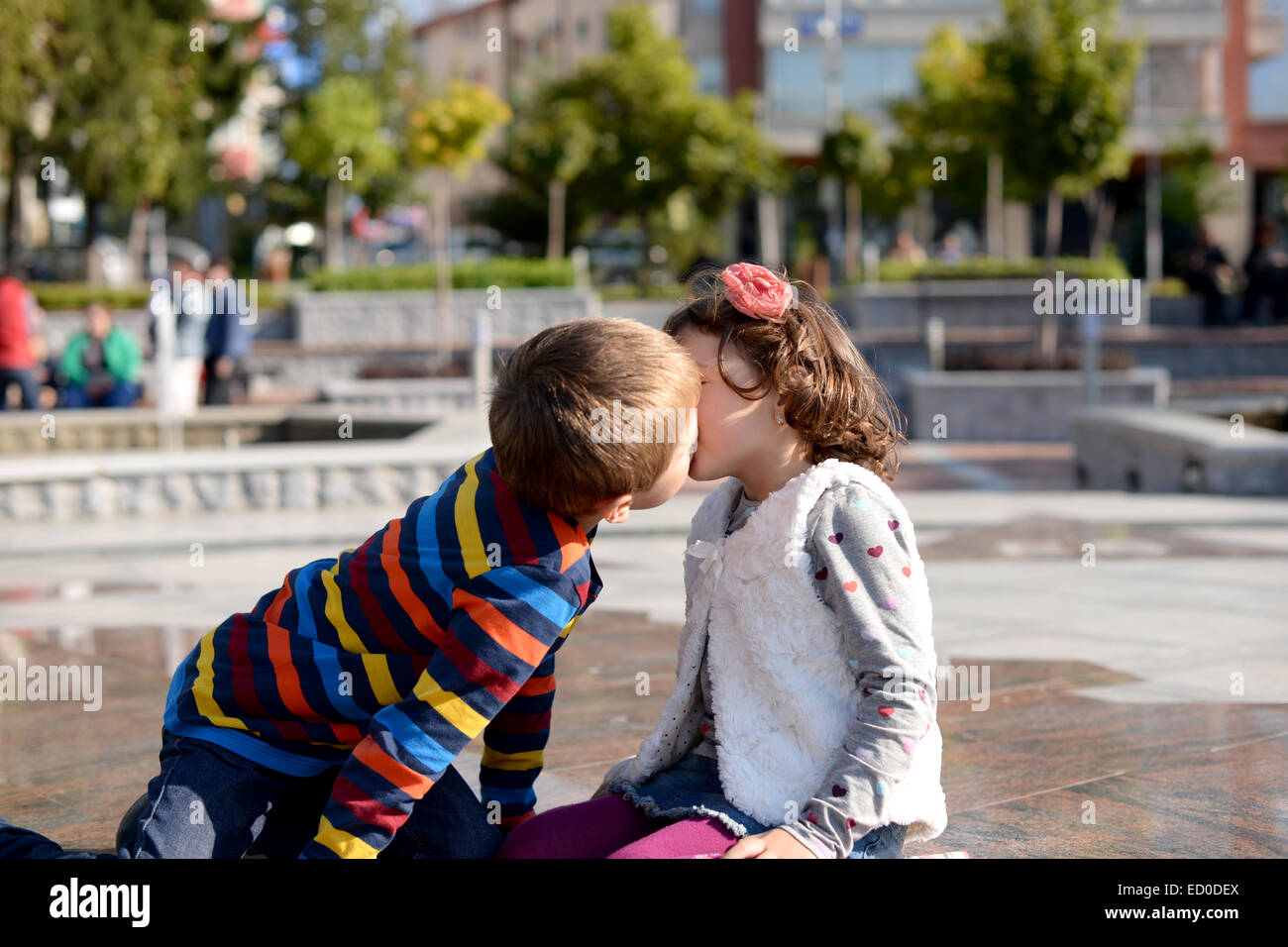 Little boy (6-7) and girl (4-5) kissing Stock Photo