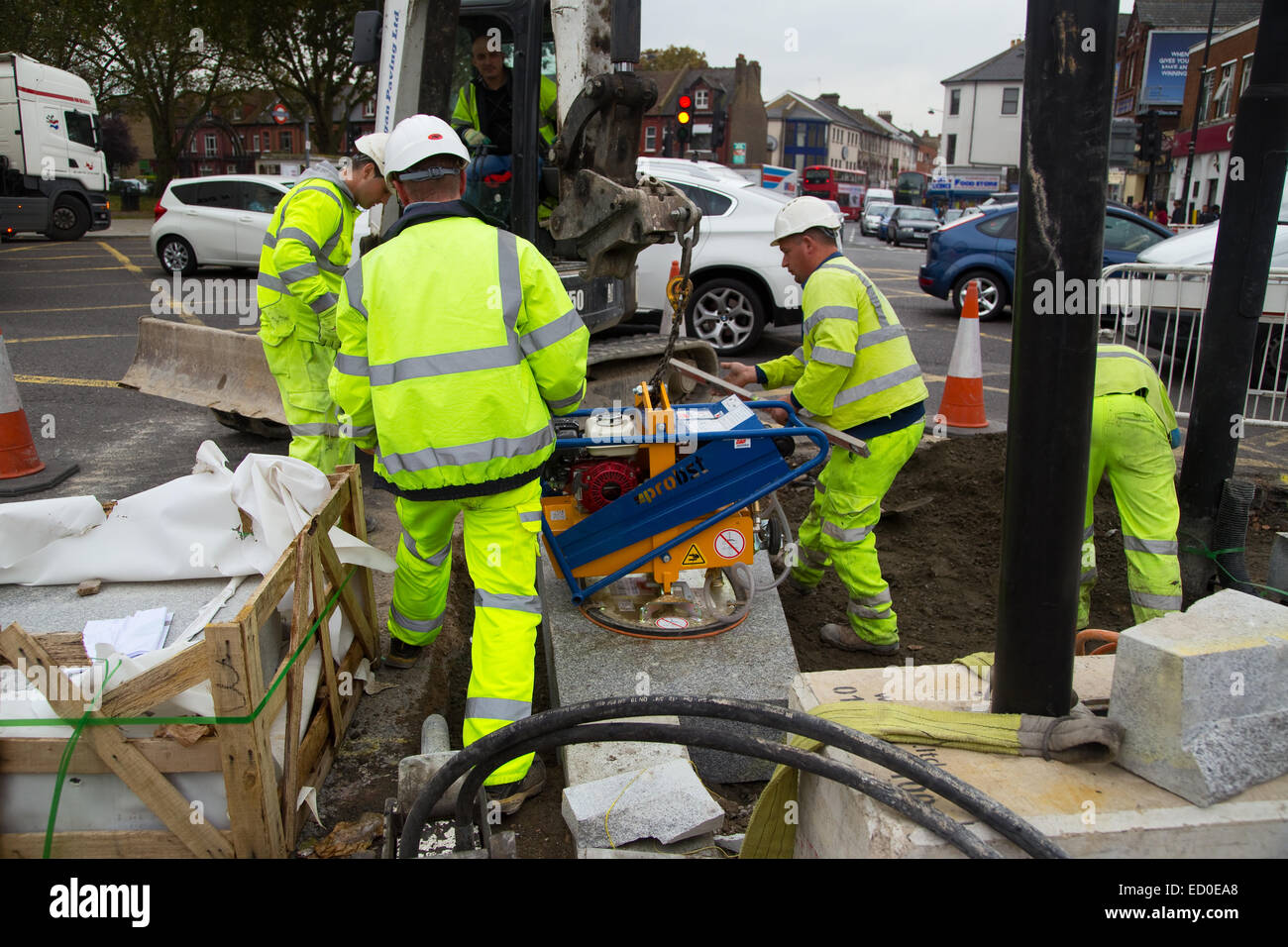 LONDON - OCTOBER 15TH: Unidentified workman using a sprobst vacuum stone magnet by Turnpike lane station on October 15th, 2014 i Stock Photo