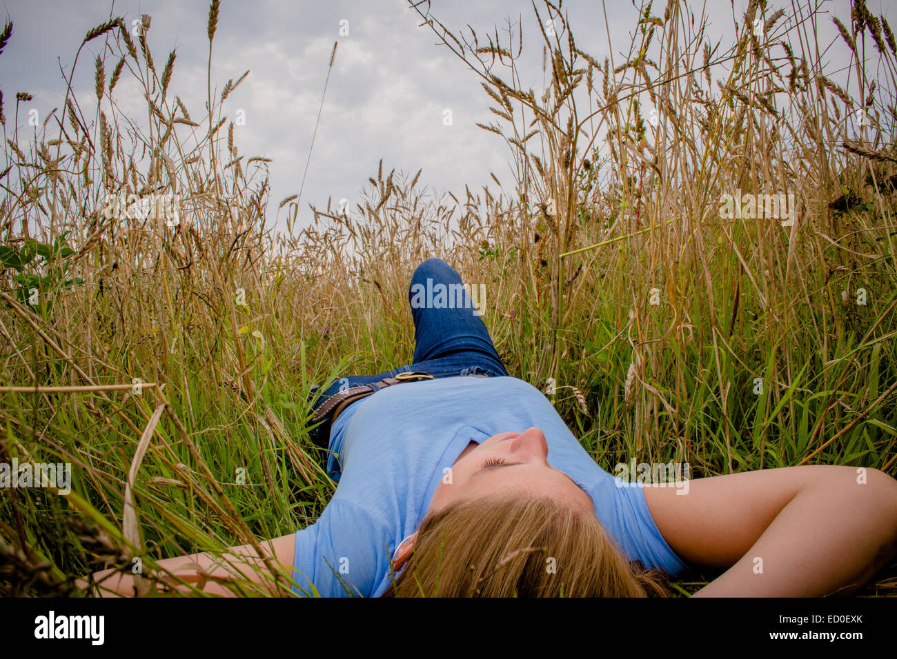 Woman lying in wheat field Stock Photo - Alamy