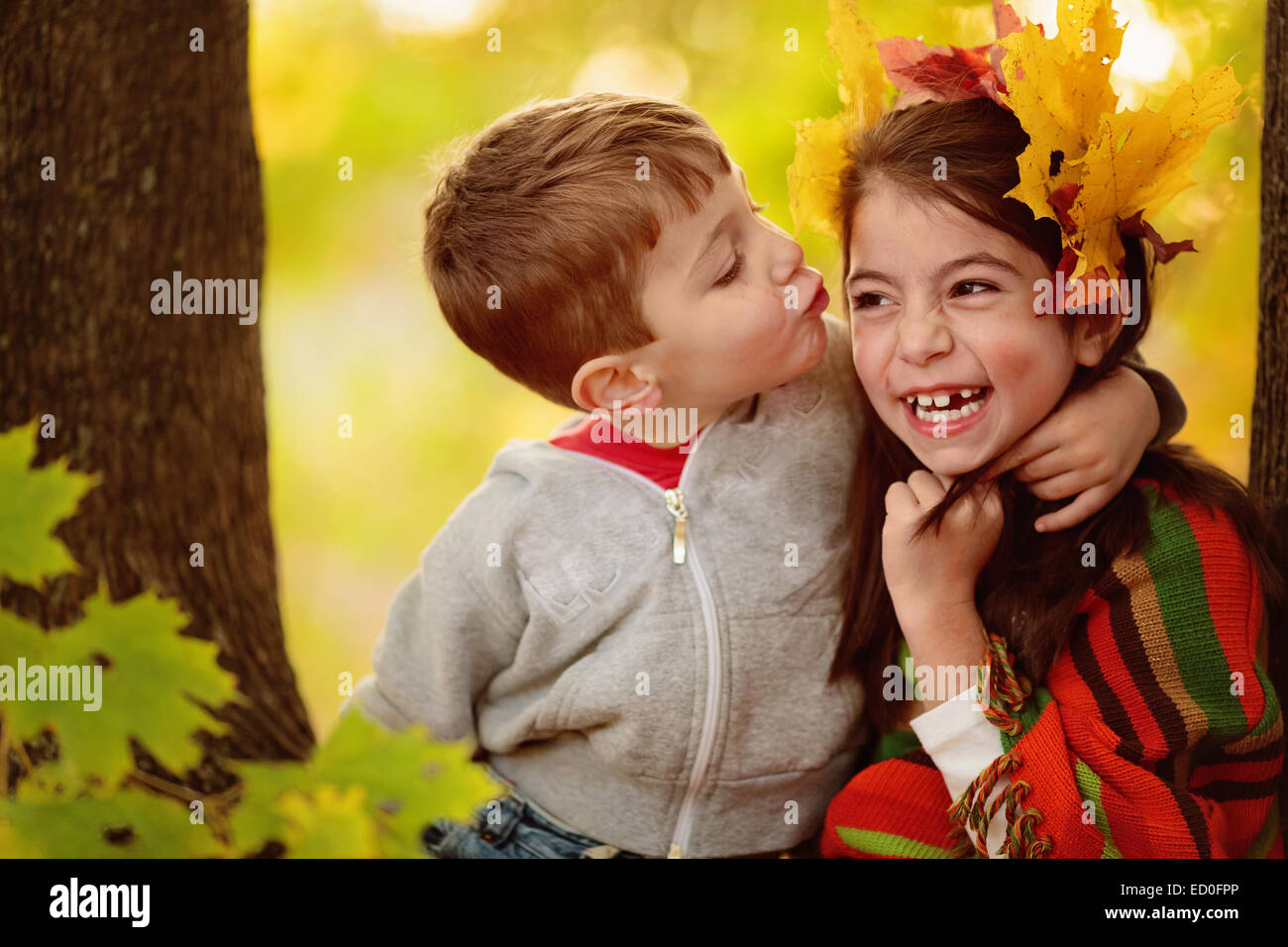 Boy trying to kiss a girl in the forest Stock Photo