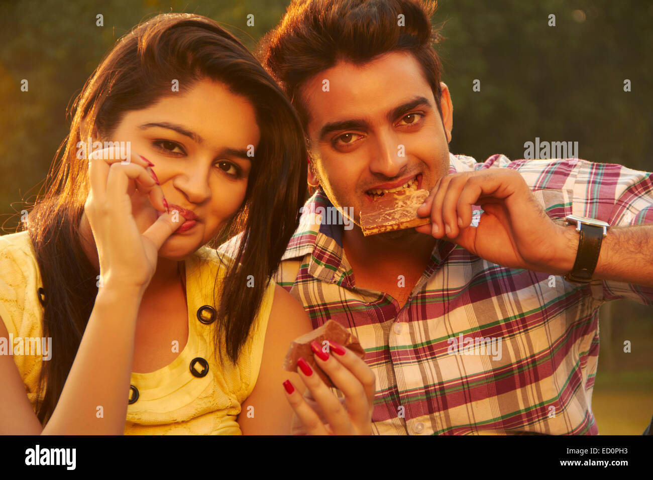 2 indian couple park Eating Chocolate Stock Photo