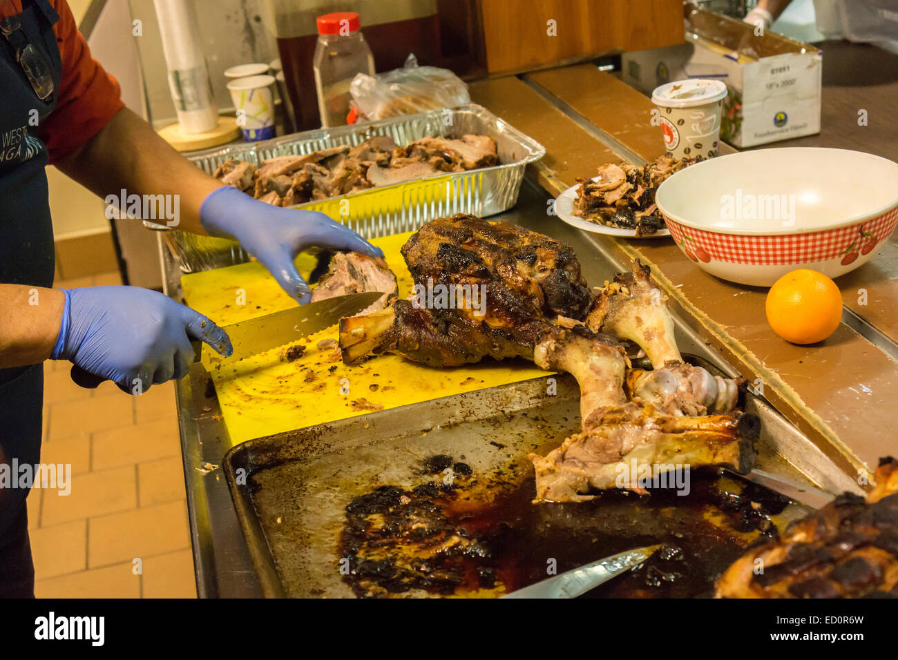 A Volunteer Cuts Pork For Lunch At The West Side Campaign Against