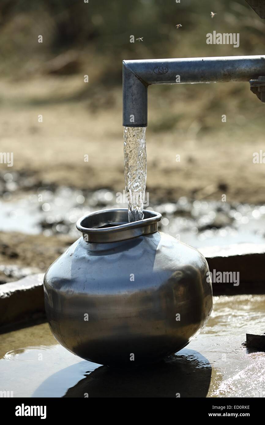 Water pot been filled at the well India Stock Photo