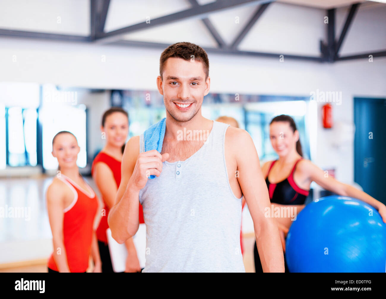 smiling man standing in front of the group in gym Stock Photo - Alamy