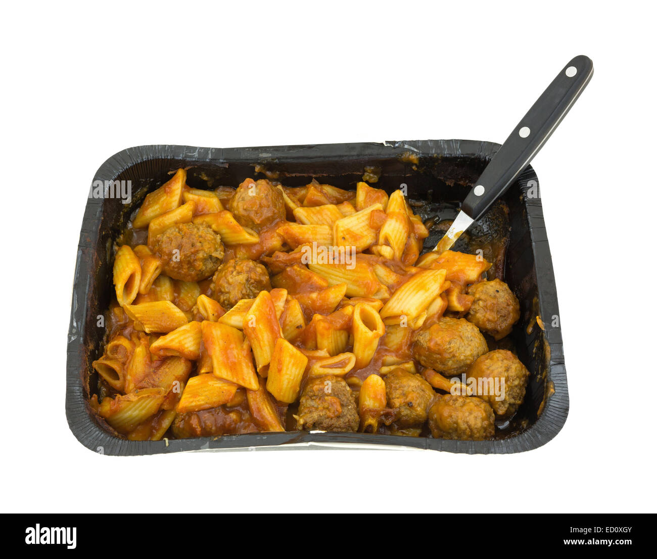 A large black tray of cooked penne pasta with meatballs in a tomato sauce and a fork against a white background. Stock Photo