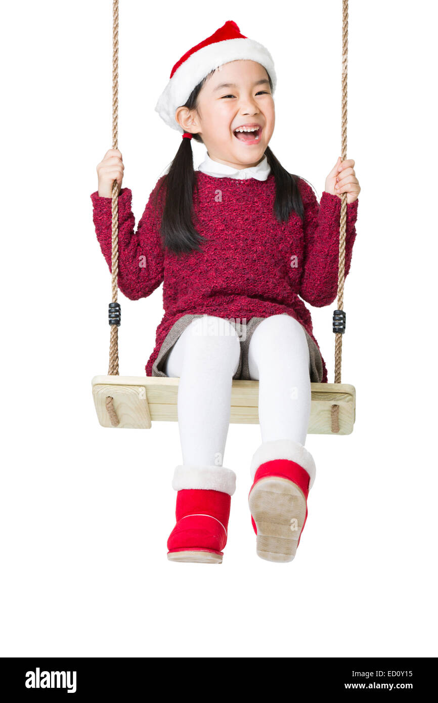 Happy girl in Santa hat on swing Stock Photo