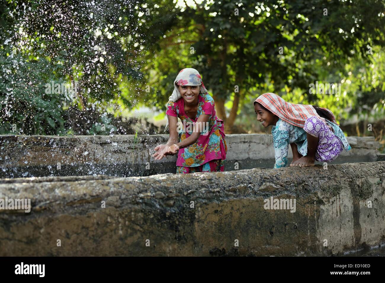 Indian girls splashing and playing with water India Stock Photo