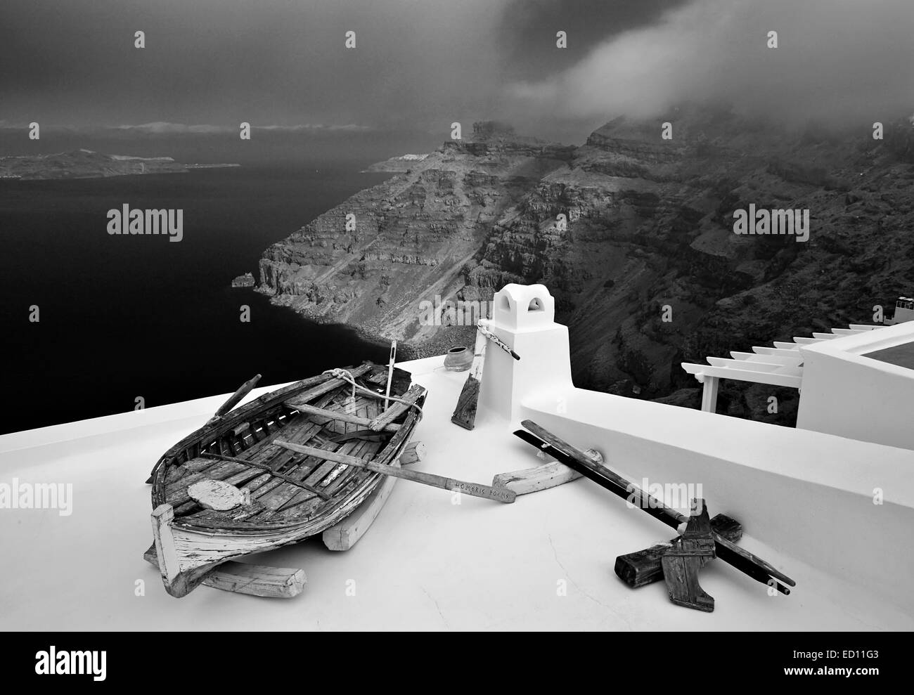 Santorini, Greece. An old boat on the roof of a house in Firostefani village, hanging over the caldera. Stock Photo