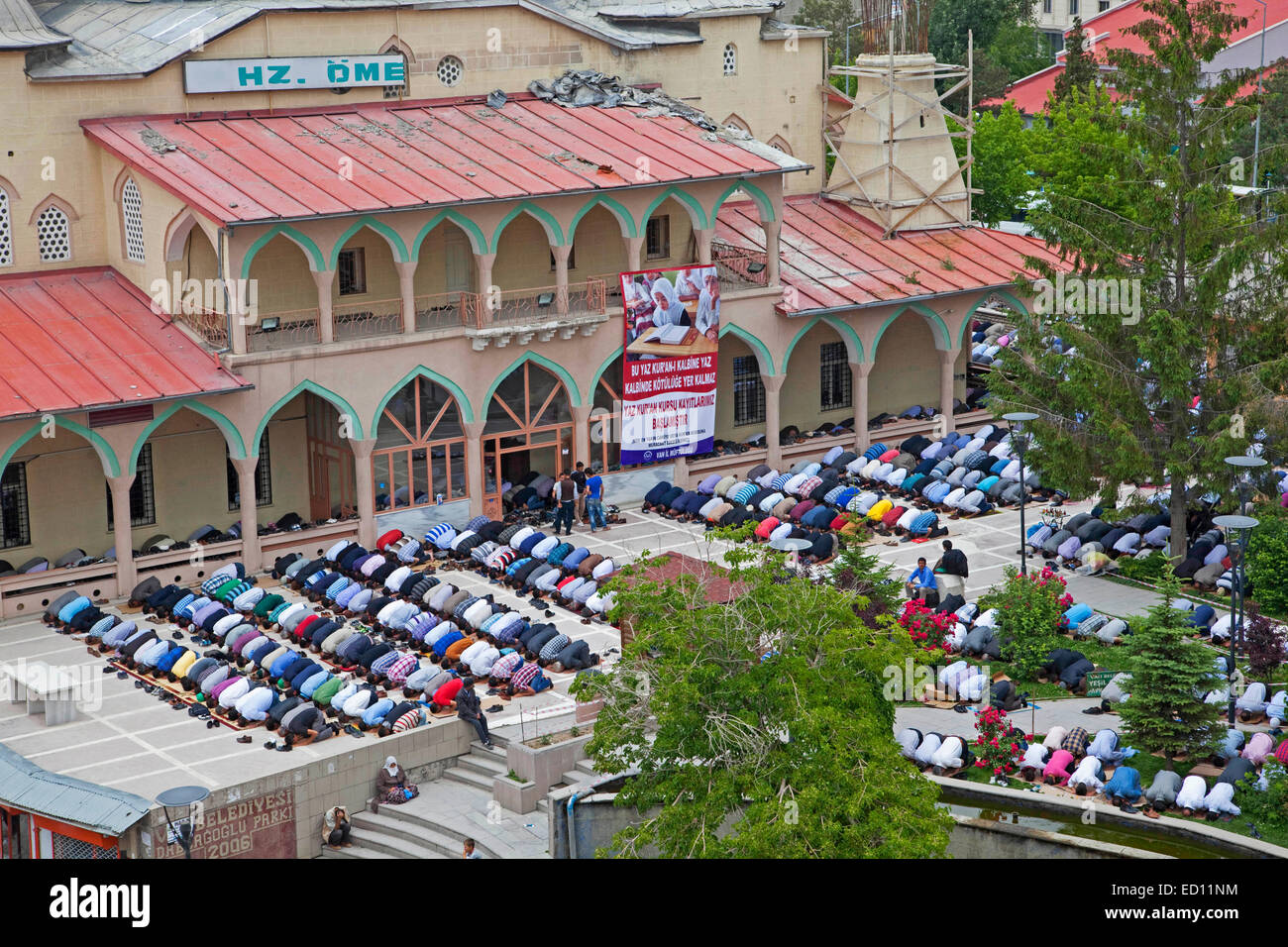 Turkish and Kurdish Muslim men in prostration praying outdoors in front of Islamic mosque for Friday prayers in Van, Turkey Stock Photo