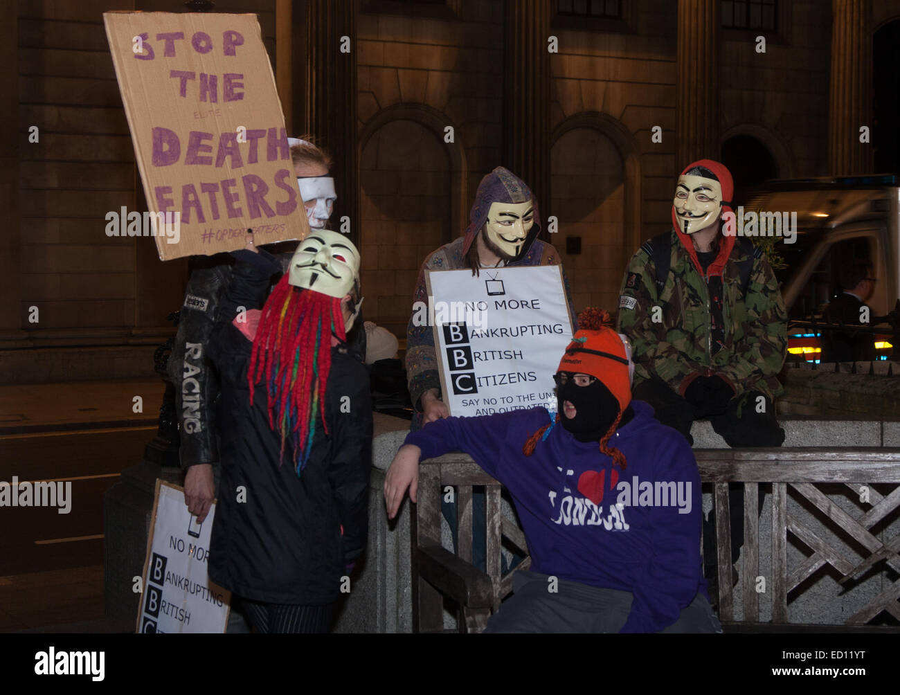 London, UK. 23rd Dec, 2014. Online activism group Anonymous march through London from the City to the BBC's HQ on Great Portland Street in protest against alleged biases and coverups of a 'paedophile ring'. PICTURED: A protester's banner demands that the 'Death Eaters' be stopped. Credit:  Paul Davey/Alamy Live News Stock Photo