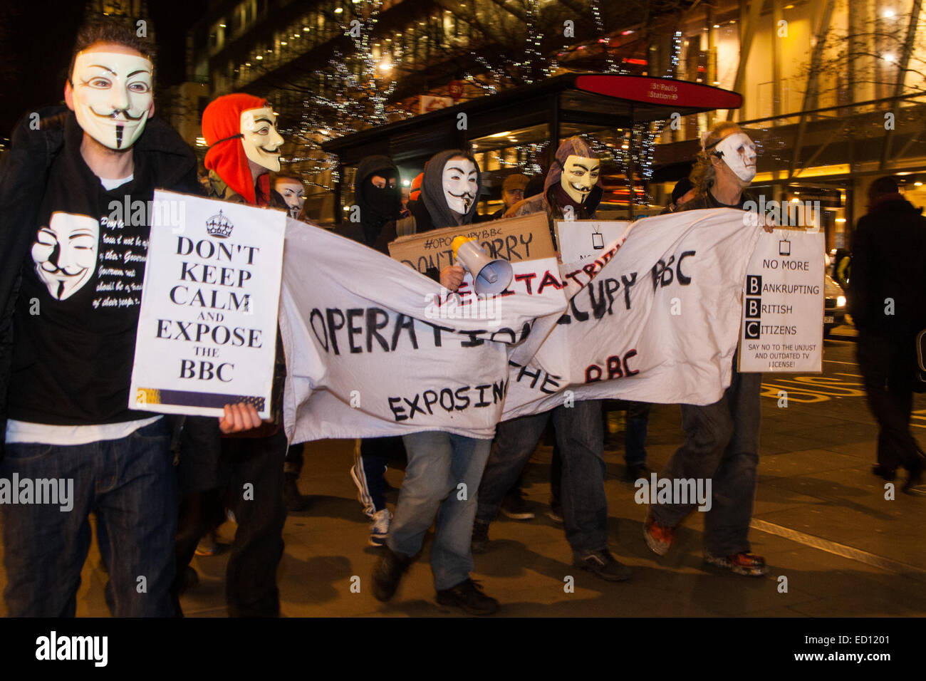 London, UK. 23rd Dec, 2014. Online activism group Anonymous march through London from the City to the BBC's HQ on Great Portland Street in protest against alleged biases and coverups of a 'paedophile ring'. PICTURED:  Protesters march towards the West End from the Bank of England. Credit:  Paul Davey/Alamy Live News Stock Photo