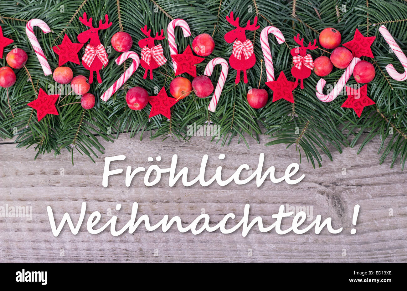 german Christmas card with Pine green, candy Canes, apples and text Merry Christmas Stock Photo