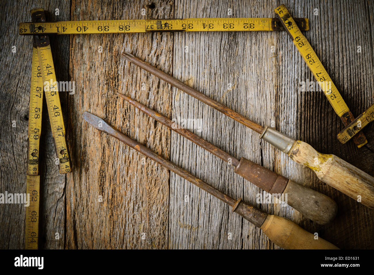 Measuring Tape and Screwdriver on Rustic Old Wood Background Stock Photo