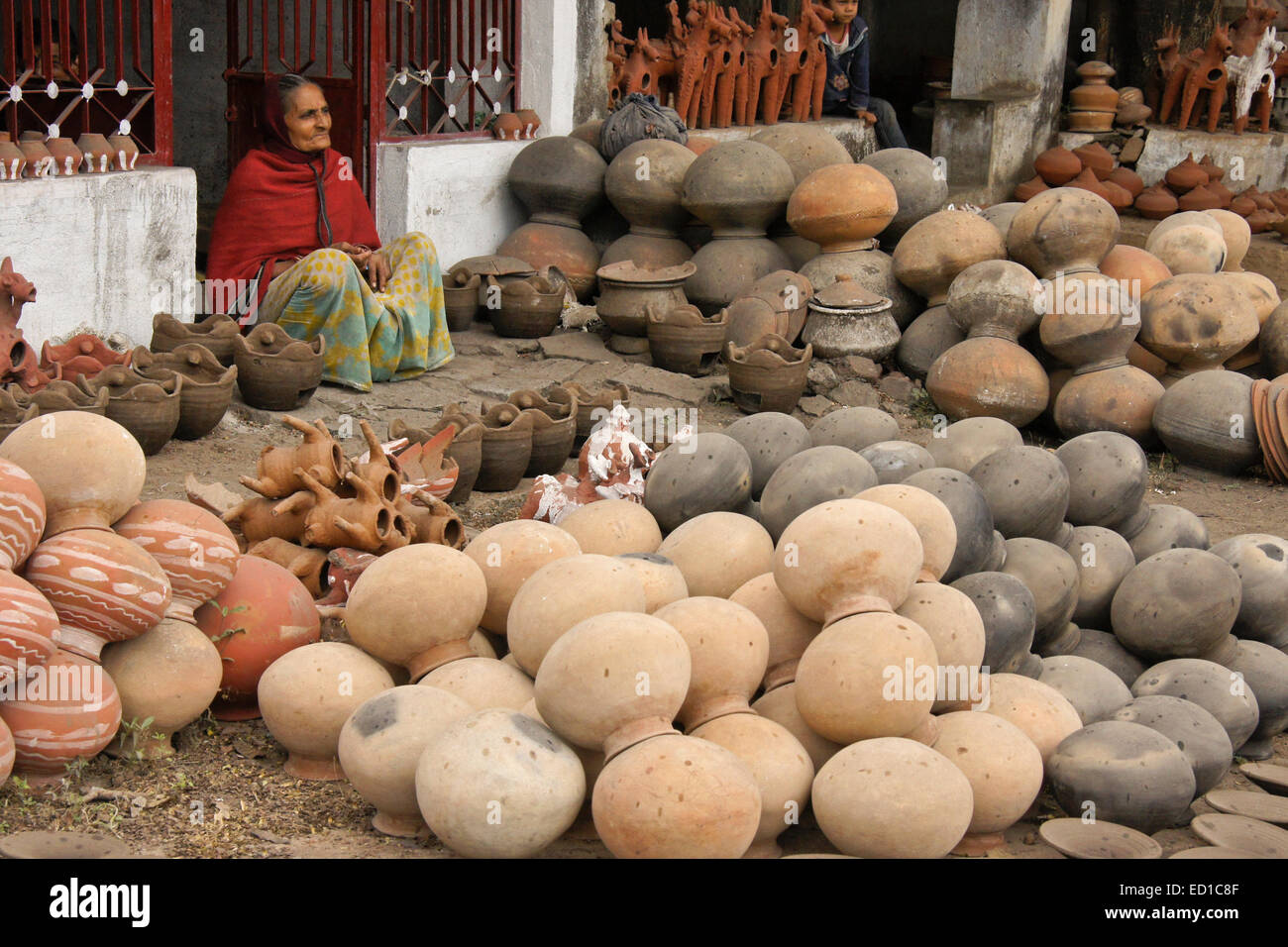 Woman selling clay pots and terracotta votive horses, Gujarat, India Stock Photo