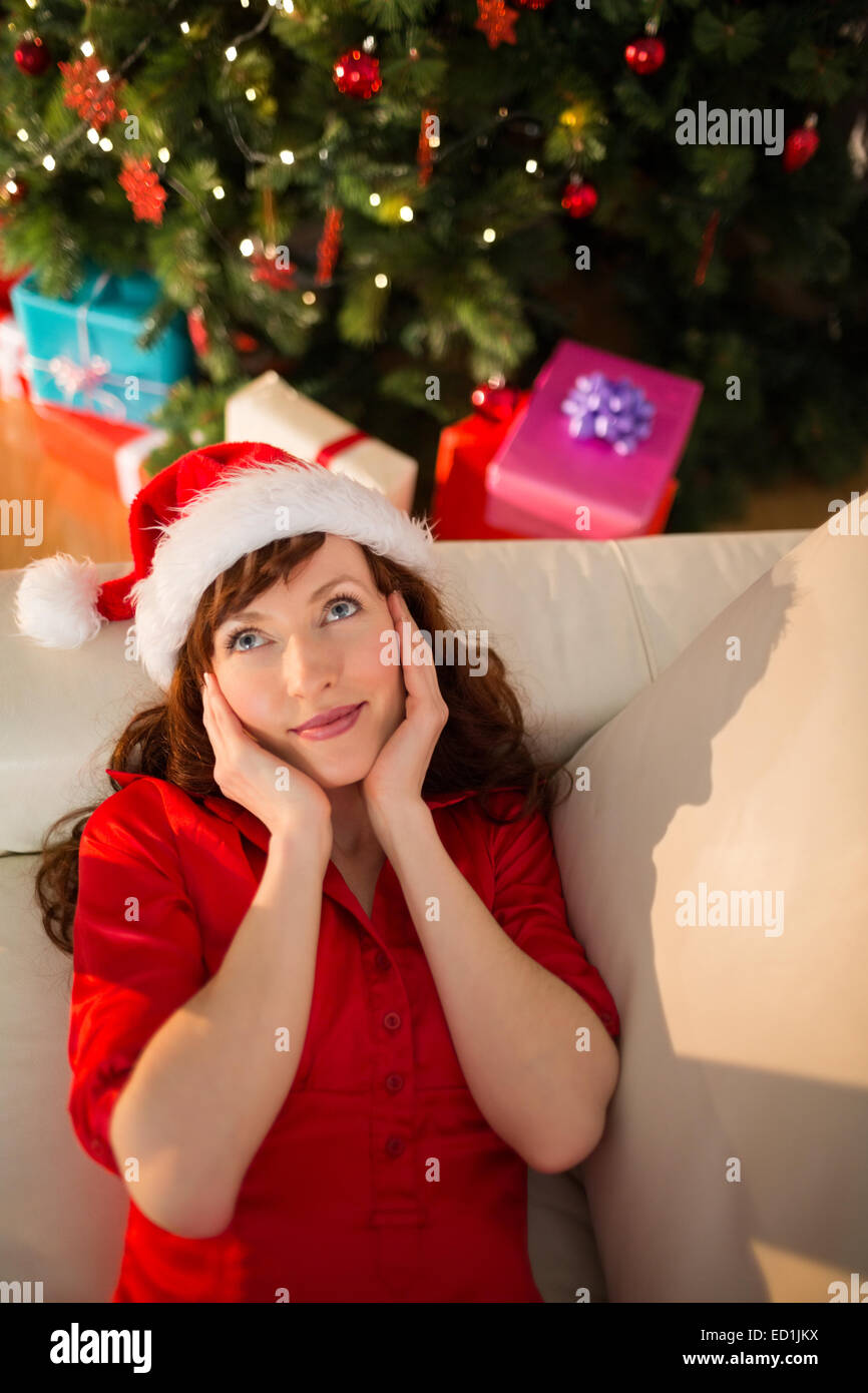 Red hair in santa hat relaxing on the couch at christmas Stock Photo