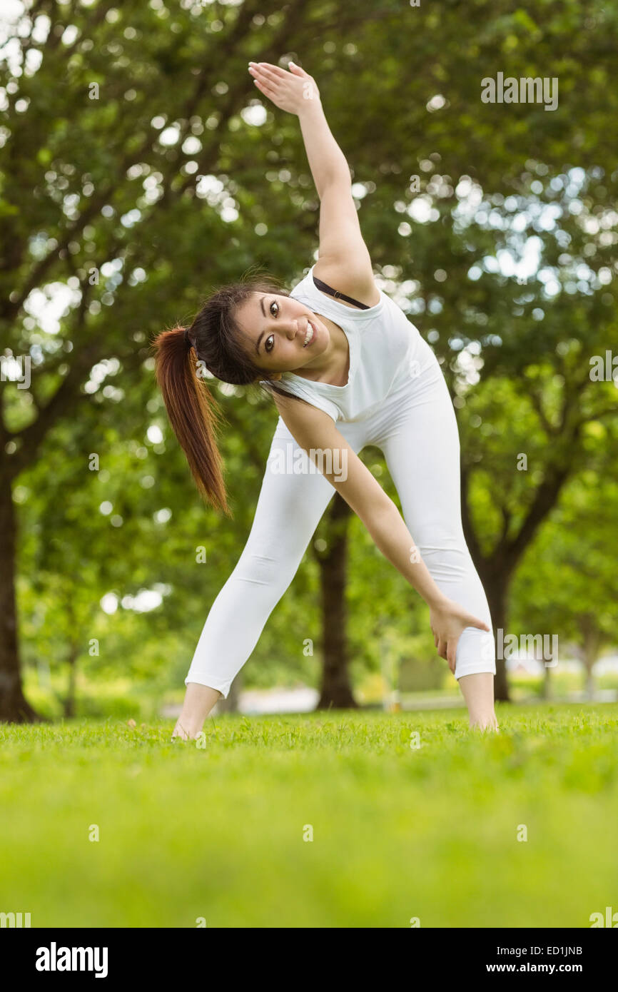 Toned woman doing stretching exercises in park Stock Photo