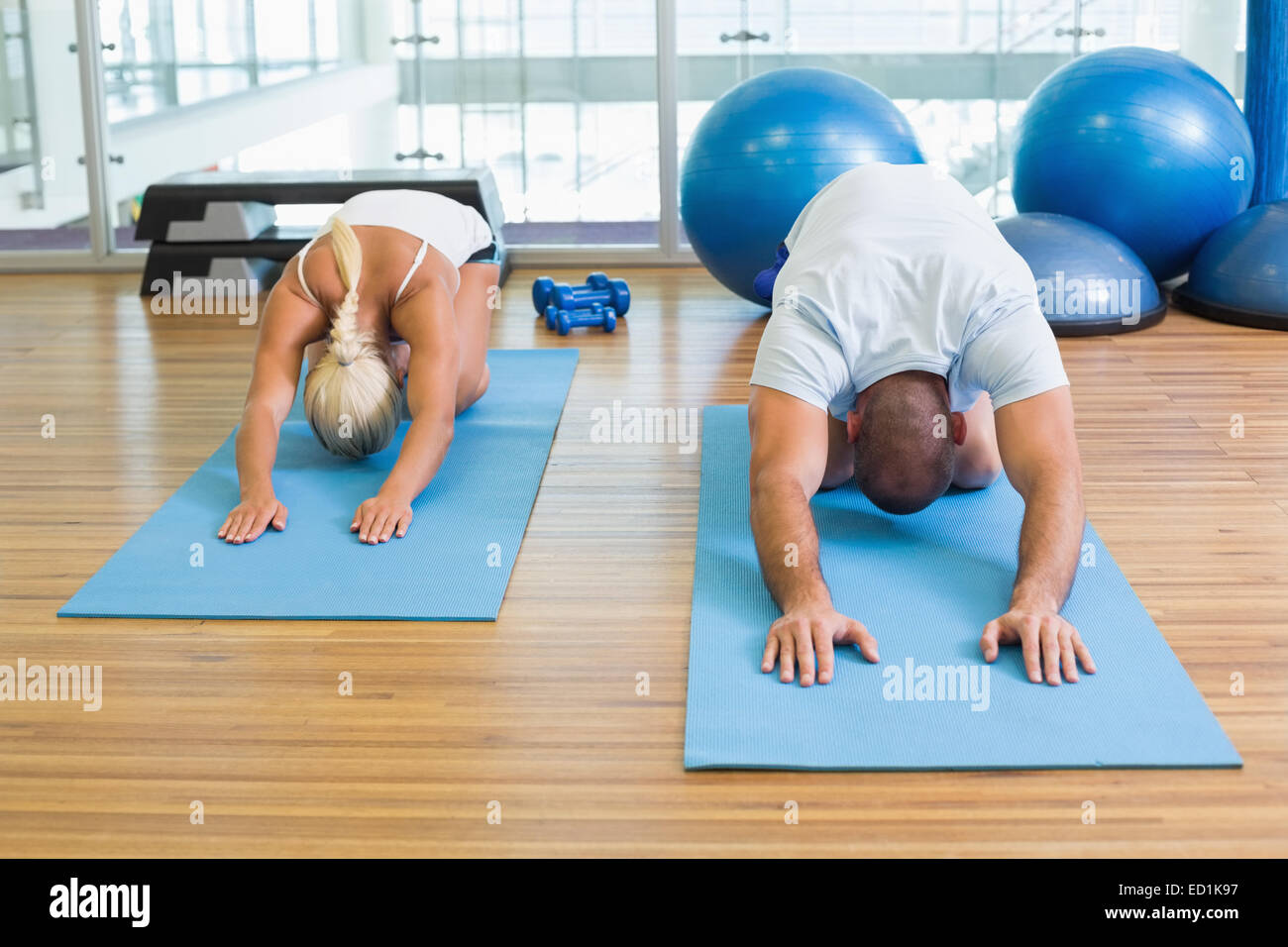 Couple in bending posture at fitness studio Stock Photo