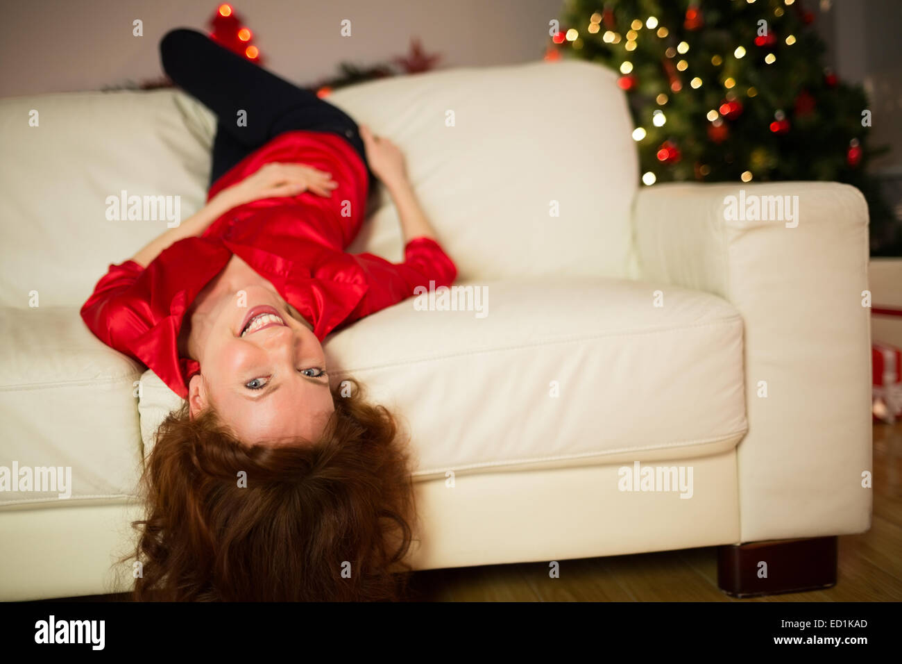 Happy redhead lying on the couch at christmas Stock Photo
