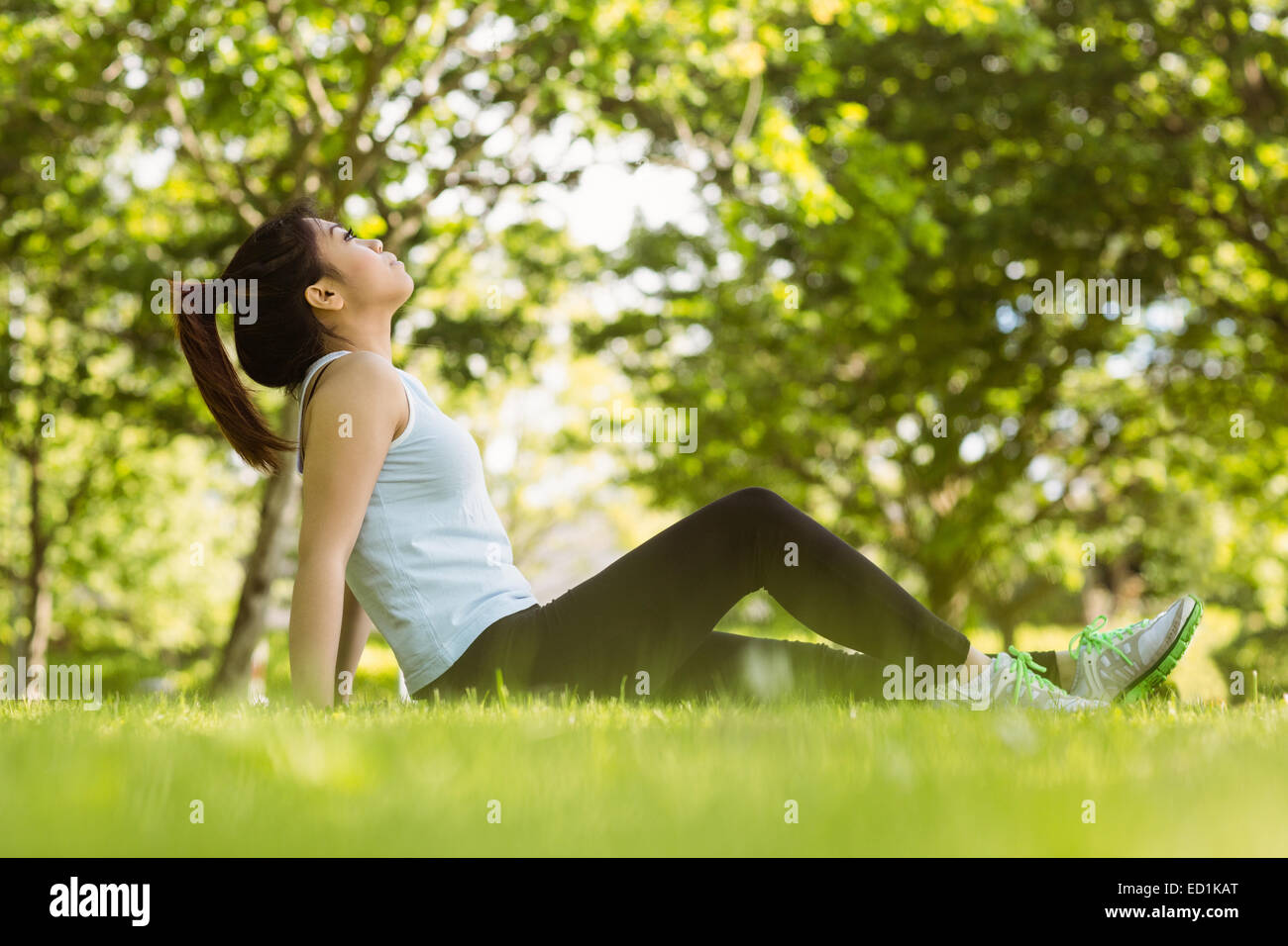 Healthy woman sitting on grass in park Stock Photo - Alamy