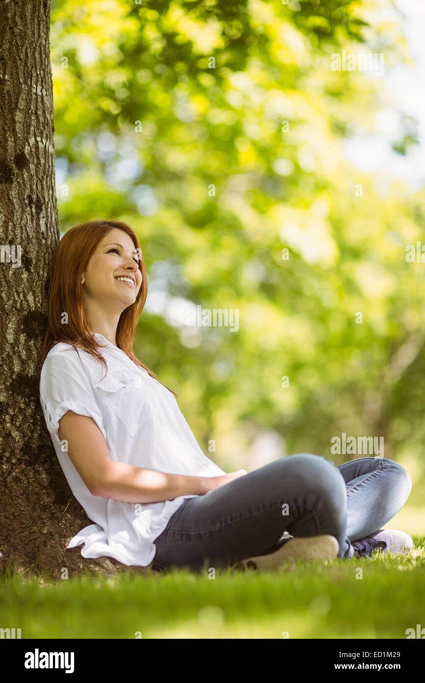 Pretty redhead sitting and smiling in casual clothing Stock Photo