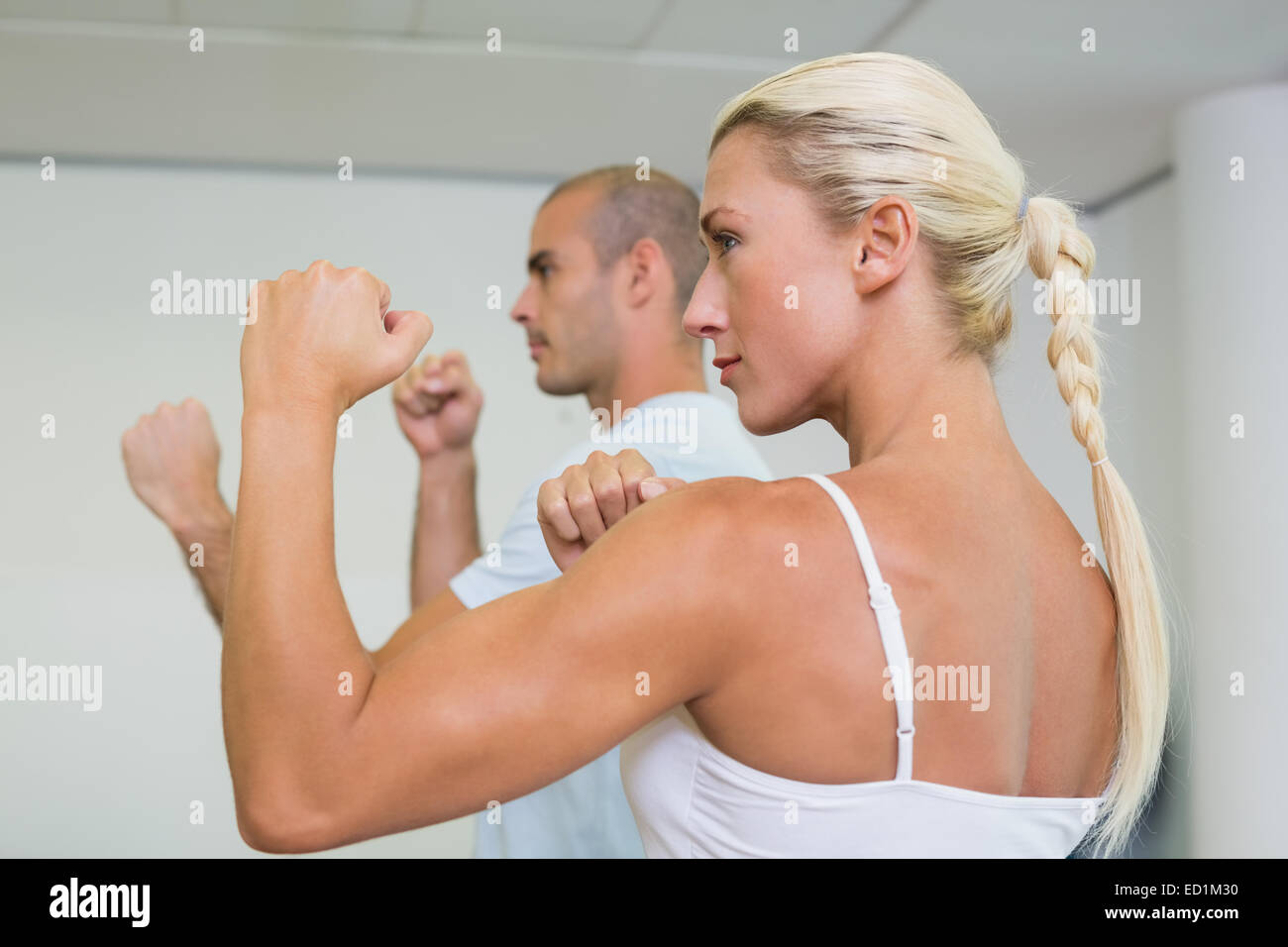 Sporty couple clenching fists at fitness studio Stock Photo