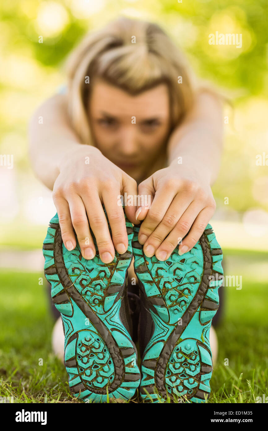 Fit blonde stretching on the grass Stock Photo - Alamy