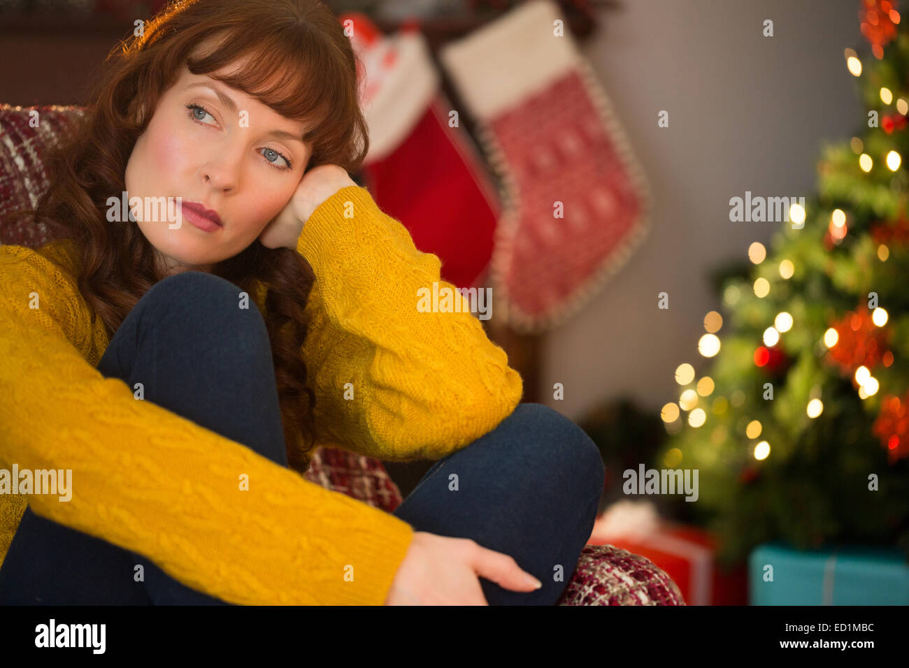 Beauty red hair thinking on the armchair at christmas Stock Photo