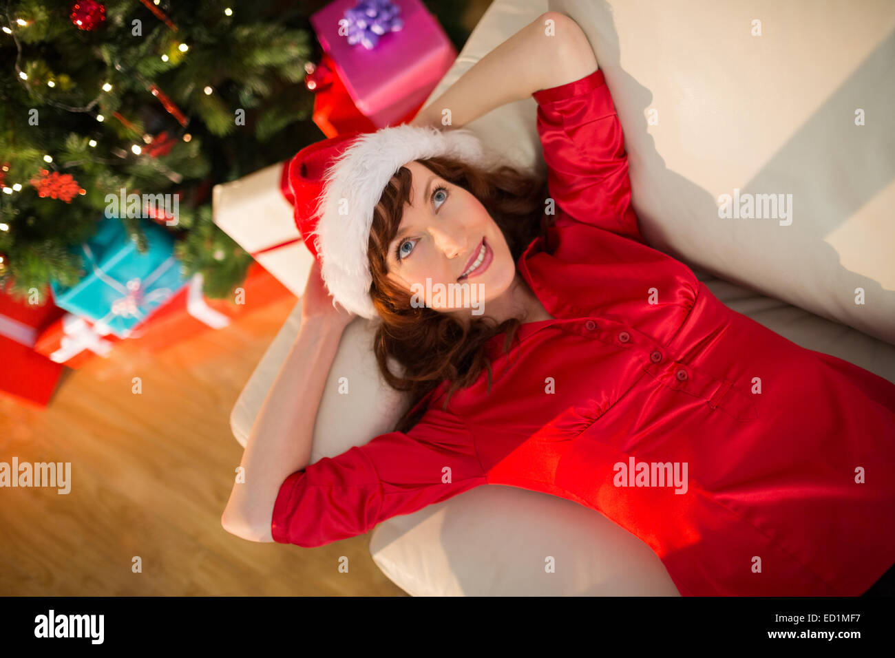 Redhead in santa hat lying on the couch at christmas Stock Photo