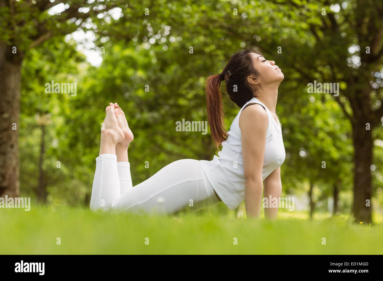 Healthy woman doing stretching exercises at park Stock Photo