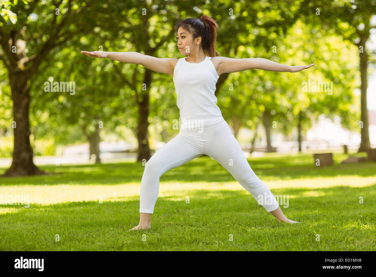 Toned woman doing stretching exercises in park Stock Photo