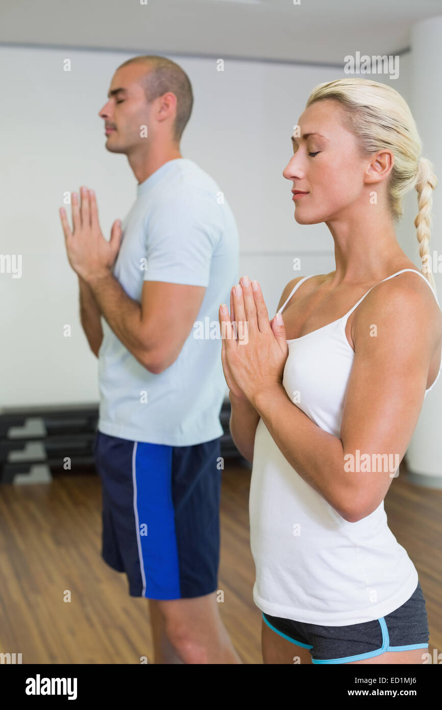 Couple with joined hands and eyes closed at fitness studio Stock Photo