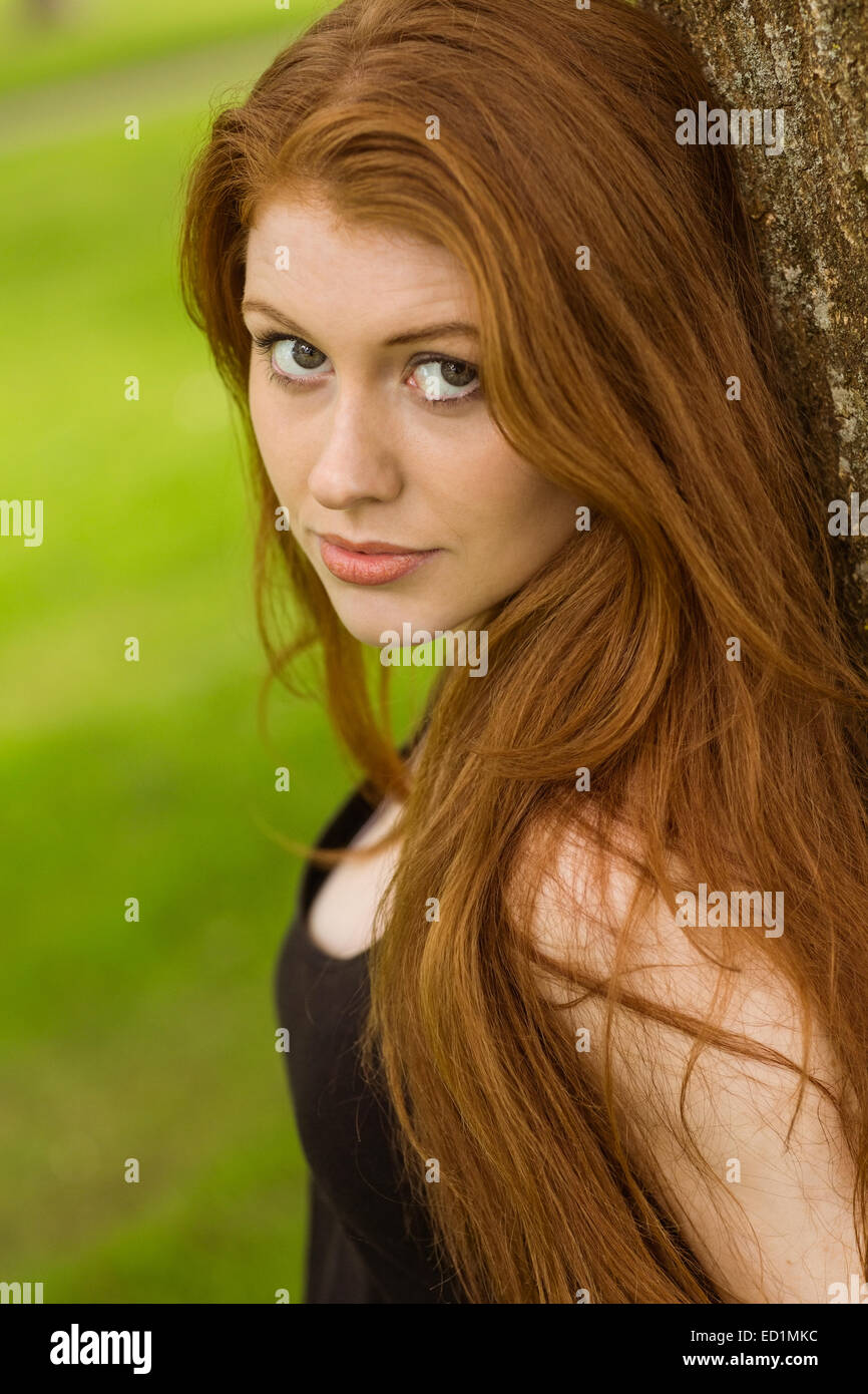 Portrait of beautiful young woman in park Stock Photo - Alamy