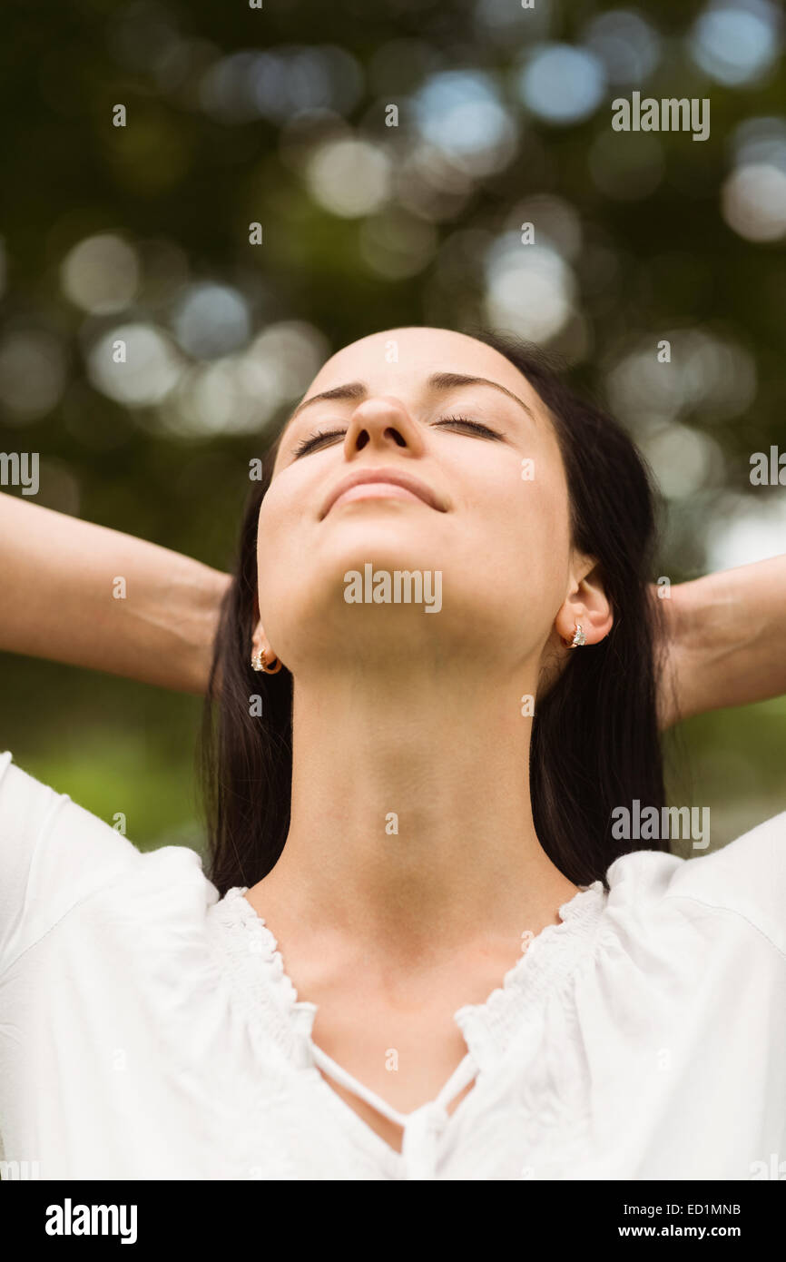 Brunette enjoying nature with her hands behind head Stock Photo