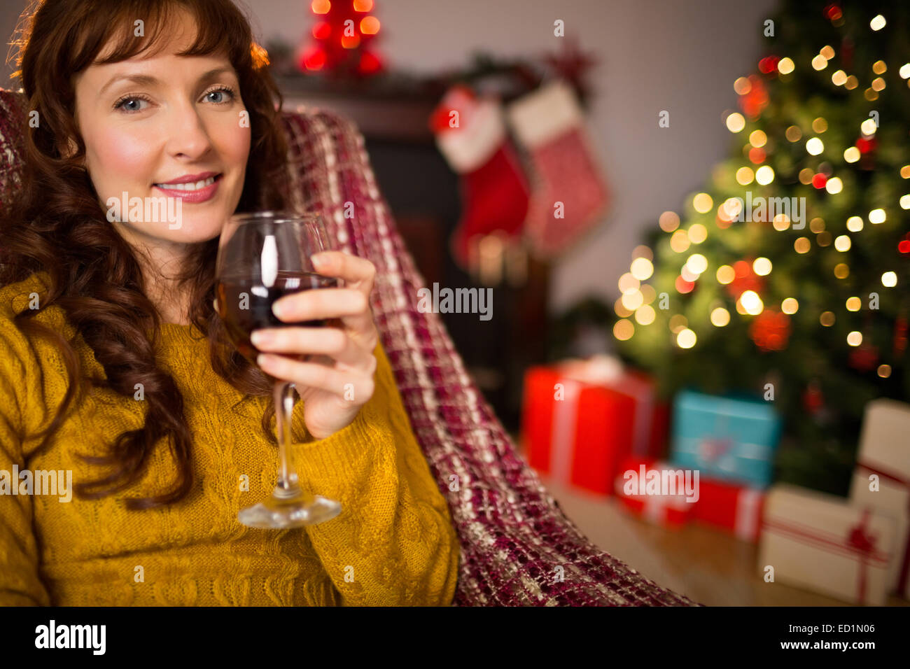 Woman sitting on a couch while holding a glass of red wine Stock Photo ...