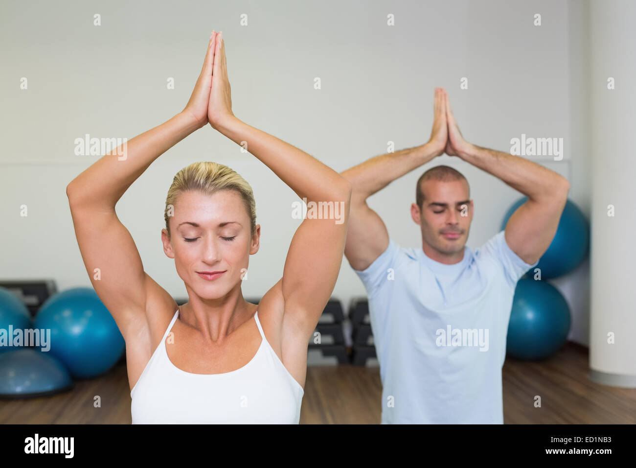 Couple with joined hands and eyes closed at fitness studio Stock Photo