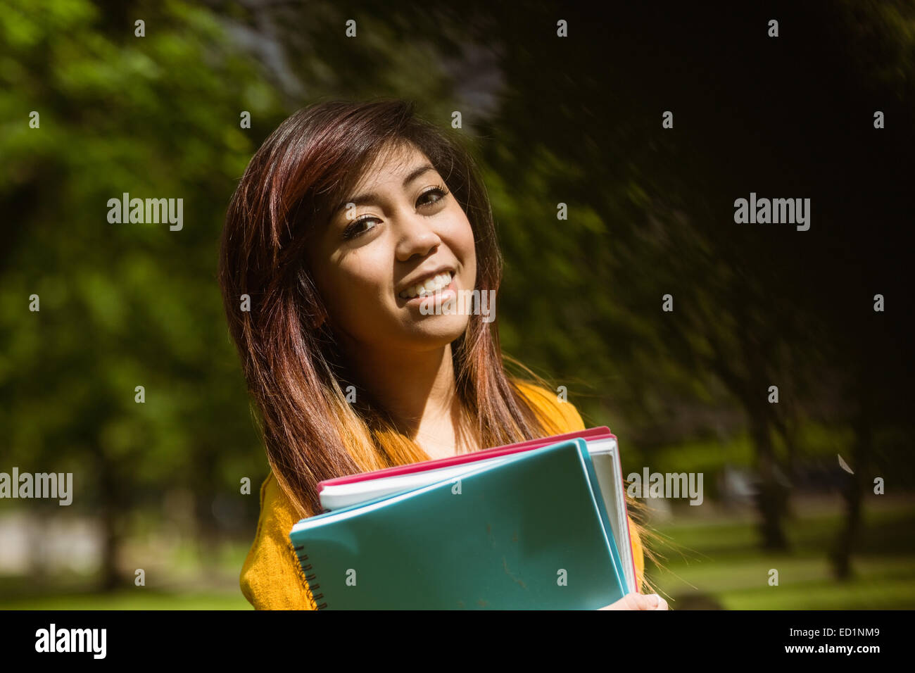 Female college student with books in park Stock Photo