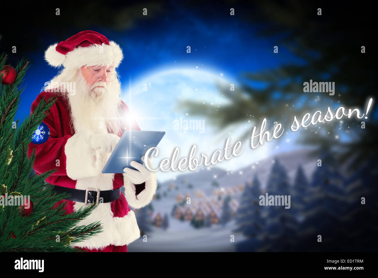 Composite image of santa uses a tablet pc Stock Photo - Alamy