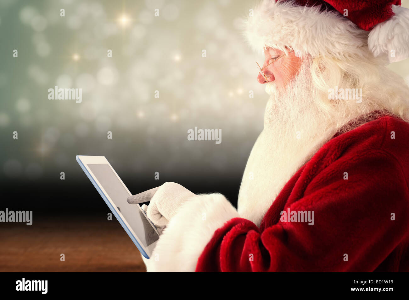Composite image of santa uses a tablet pc Stock Photo - Alamy