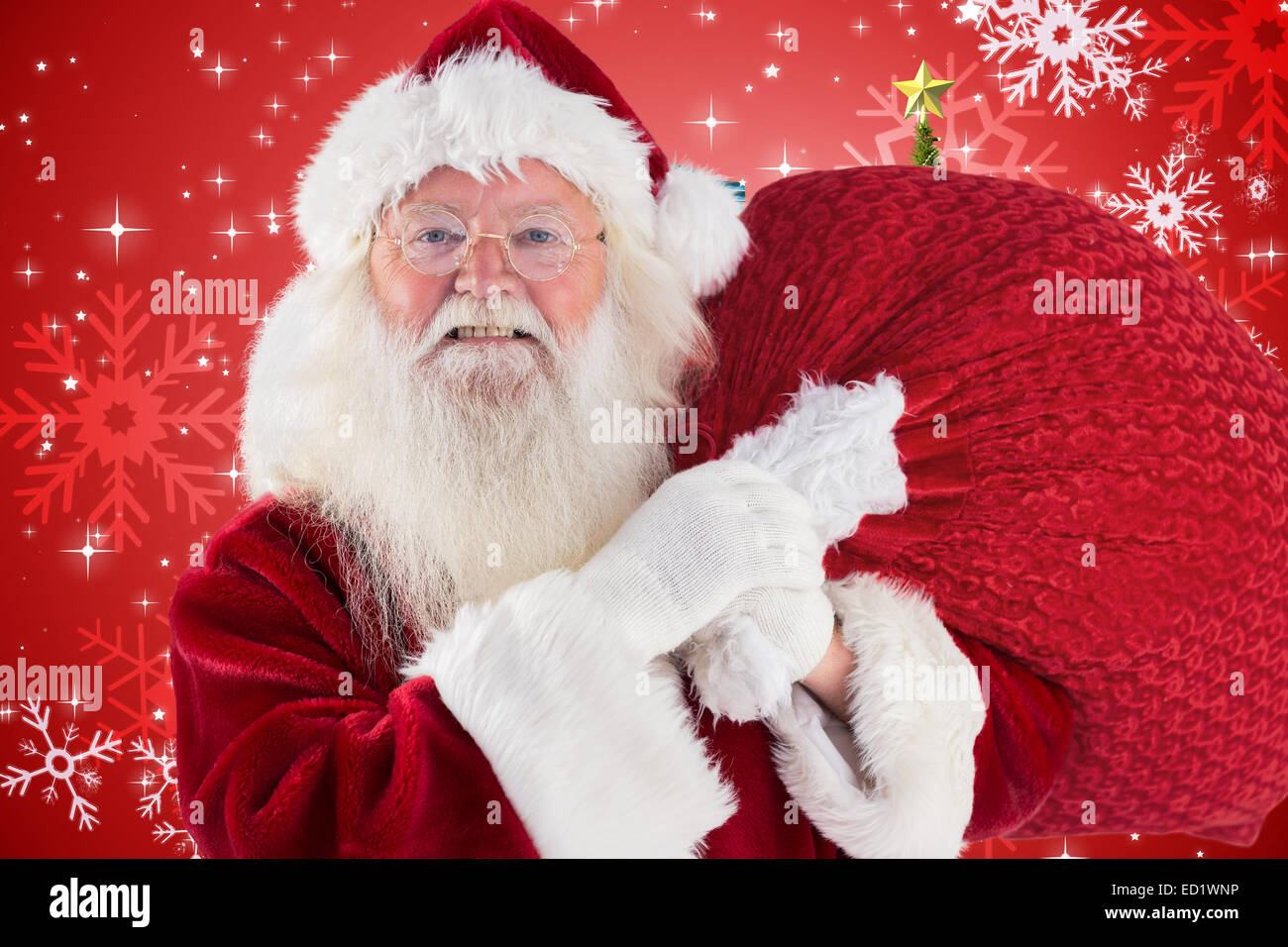 Composite image of jolly santa carries his sack Stock Photo - Alamy