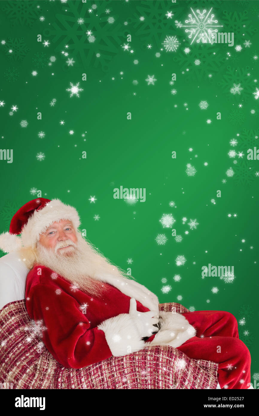 Composite image of santa holding his belly on the armchair Stock Photo ...
