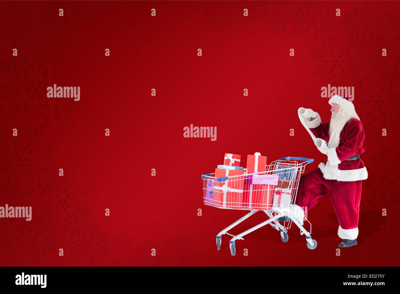 Composite image of santa pushes a shopping cart while reading Stock
