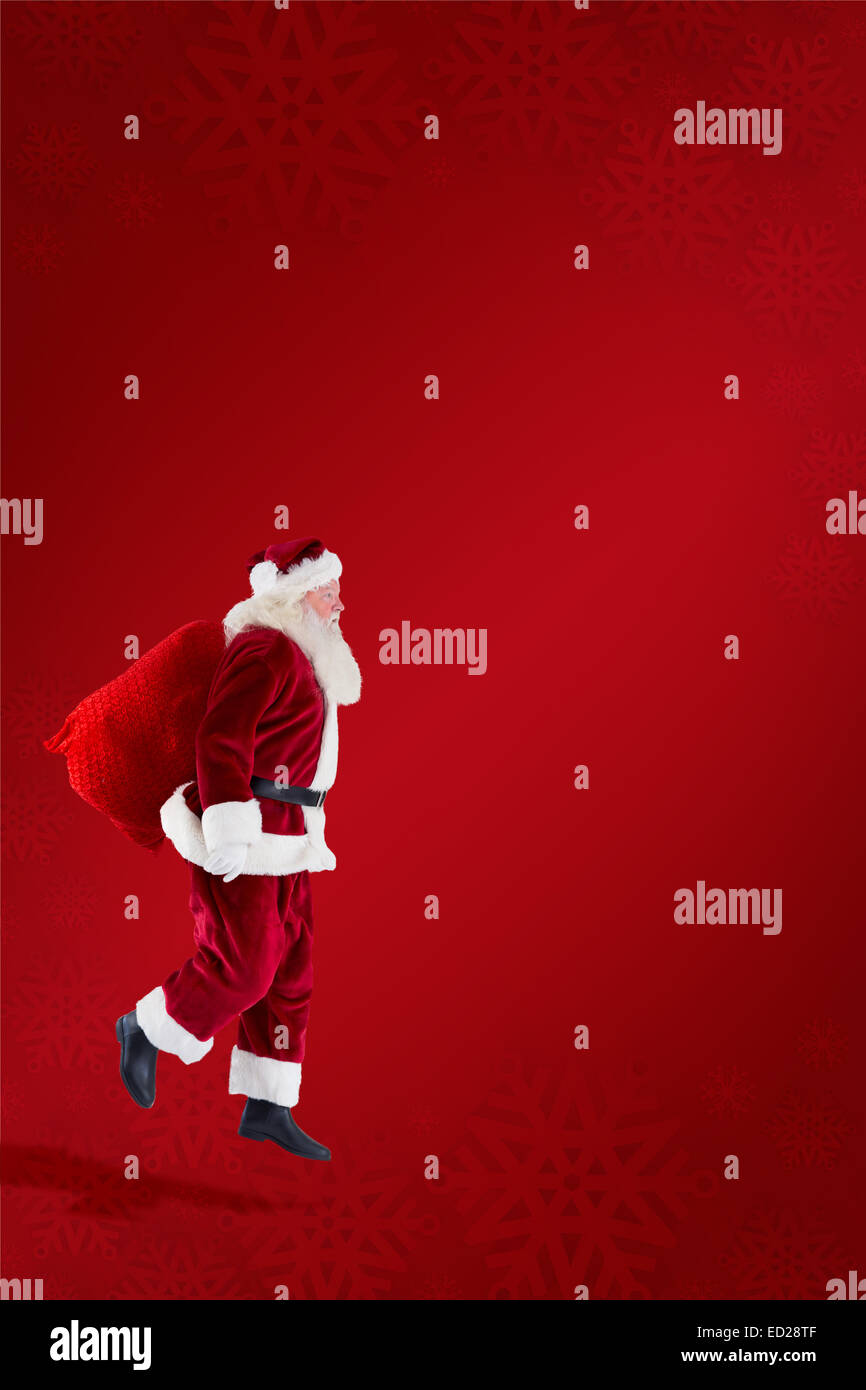 Composite image of santa claus carrying sack Stock Photo - Alamy