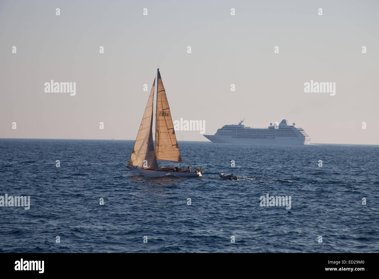 A Cruise ship dominates the horizon, and in the fore ground a yacht seems to be a more relaxed form of travel. Stock Photo
